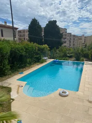 a large blue swimming pool in front of some buildings at Maisonnette Cagnes in Cagnes-sur-Mer