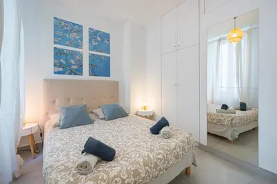 a bedroom with a bed with blue pillows and a mirror at Stunning flat by the beach, Carre d'or-Negresco in Nice
