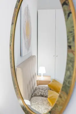 a mirror reflecting a white chair in a room at Stunning flat by the beach, Carre d'or-Negresco in Nice