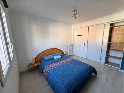 a bedroom with a large bed with a blue blanket at Spacieux/paisible 5 pièces en plein coeur de Nice in Nice