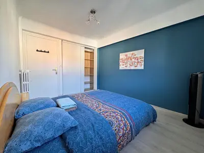 a bedroom with a large bed with blue walls at Spacieux/paisible 5 pièces en plein coeur de Nice in Nice