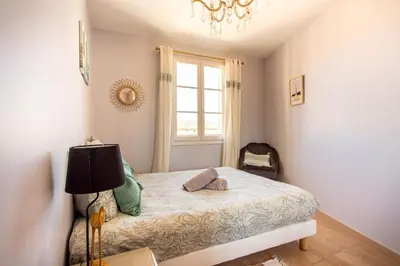 a bedroom with a bed with a lamp and a window at Providence - ELEGANT F3, VUE INCROYABLE, BALCON,ASCENSEUR, WIFI in Nice