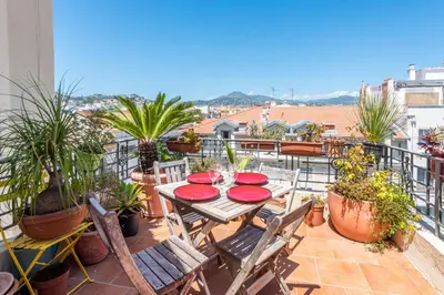 a patio with a table and chairs on a balcony at La terrasse de Rossini in Nice