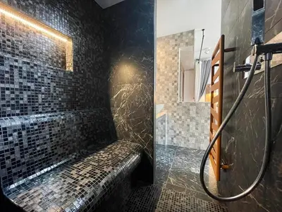 a bathroom with a walk in shower next to a brick wall at Escondida in Nice