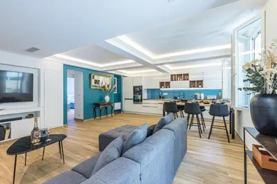 a living room with a blue couch and a kitchen at Luxury 3 Bdr Garden & Parking - Angels' Garden in Nice