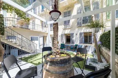 a patio with a table and chairs and a wine barrel at Luxury 3 Bdr Garden & Parking - Angels' Garden in Nice