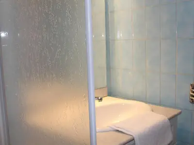 a bathroom with a tub and a shower with a towel at Studio Cosy avec Terrasse et Parking, à 30m de la Mer, Cagnes-sur-Mer - FR-1-252A-56 in Cagnes-sur-Mer