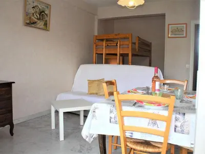a living room with a table and a bed at Studio Cosy avec Terrasse et Parking, à 30m de la Mer, Cagnes-sur-Mer - FR-1-252A-56 in Cagnes-sur-Mer