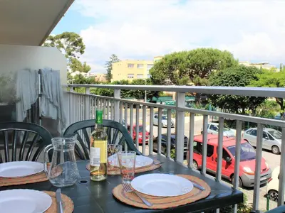 a table with plates and wine glasses on a balcony at Studio Cosy avec Terrasse et Parking, à 30m de la Mer, Cagnes-sur-Mer - FR-1-252A-56 in Cagnes-sur-Mer