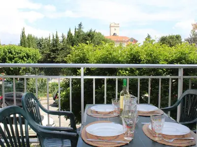 a table with plates and glasses on a balcony at Studio Cosy avec Terrasse et Parking, à 30m de la Mer, Cagnes-sur-Mer - FR-1-252A-56 in Cagnes-sur-Mer