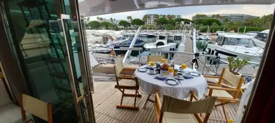 a table on a balcony with boats in a marina at Yacht Charter Nice Cannes Antibes in Nice
