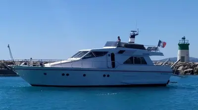 a white yacht in the water with a lighthouse in the background at Yacht Charter Nice Cannes Antibes in Nice