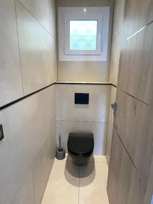 a small bathroom with a black toilet with a window at MyBlueVista LUXURY PANORAMIC SEA VIEW APARTMENTS CAP D AIL NEAR MONACO in Cap d'Ail