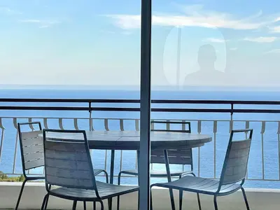 a table and chairs on a balcony with the ocean at MyBlueVista LUXURY PANORAMIC SEA VIEW APARTMENTS CAP D AIL NEAR MONACO in Cap d'Ail