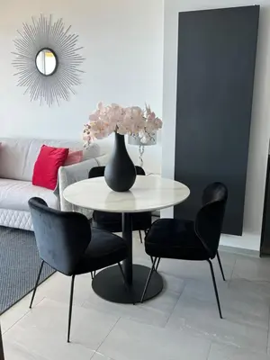 a table with chairs and a vase on it in a living room at MyBlueVista LUXURY PANORAMIC SEA VIEW APARTMENTS CAP D AIL NEAR MONACO in Cap d'Ail