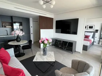 a living room with a couch and a table with flowers at MyBlueVista LUXURY PANORAMIC SEA VIEW APARTMENTS CAP D AIL NEAR MONACO in Cap d'Ail