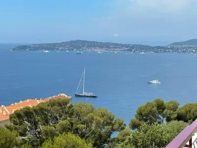 a sailboat in a large body of water with two boats at MyBlueVista LUXURY PANORAMIC SEA VIEW APARTMENTS CAP D AIL NEAR MONACO in Cap d'Ail