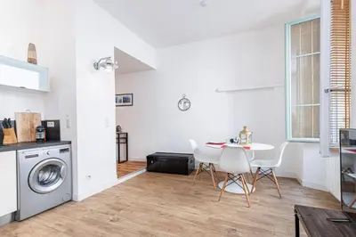 a kitchen and dining room with a table and a washing machine at Bright 1 Bdr in the Old Town in Nice