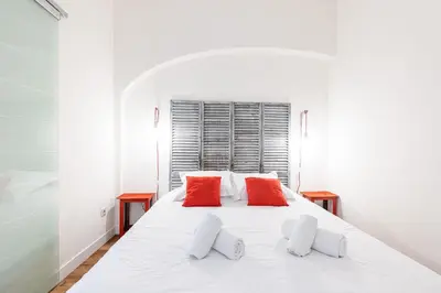 a bedroom with a white bed with two red pillows at Bright 1 Bdr in the Old Town in Nice