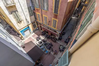 an overhead view of a group of people in a courtyard between buildings at Bright 1 Bdr in the Old Town in Nice