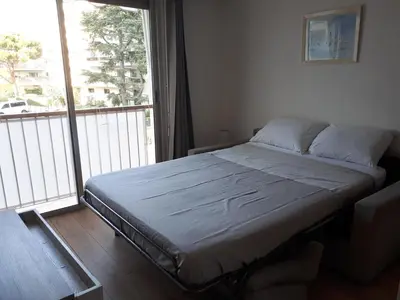 a bed in a room with a large window at Studio bord de mer in Saint-Laurent-du-Var