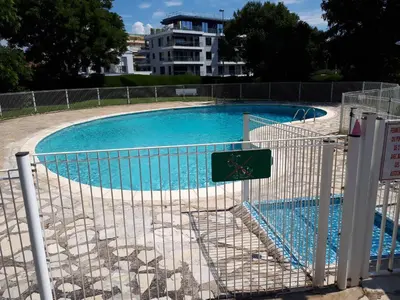 a swimming pool with a fence around it at Studio bord de mer in Saint-Laurent-du-Var