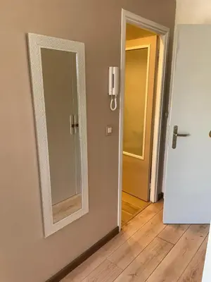 a mirror on a wall next to a door at Studio bord de mer in Saint-Laurent-du-Var
