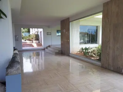 an empty room with wooden floors and large windows at Studio bord de mer in Saint-Laurent-du-Var