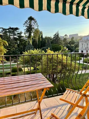 a picnic table and two chairs on a balcony at Air-conditioned apartment with garage near the sea in Nice