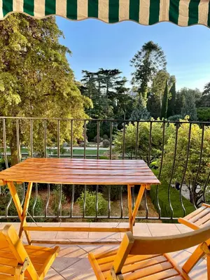 a wooden picnic table and two chairs on a balcony at Air-conditioned apartment with garage near the sea in Nice