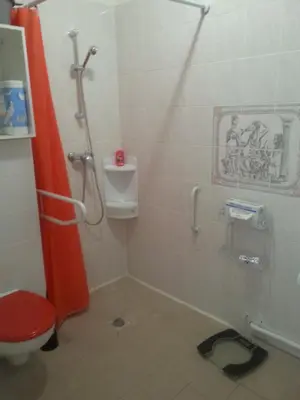 a bathroom with a shower and a toilet with a red door at La Plage in Cagnes-sur-Mer