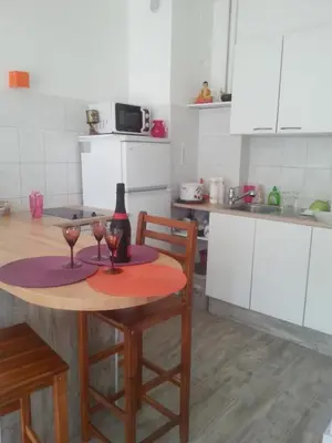 a kitchen with a table with two wine glasses on it at La Plage in Cagnes-sur-Mer