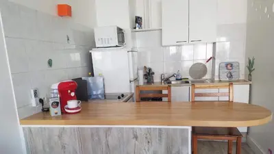 a kitchen with a wooden counter top with a red appliance at La Plage in Cagnes-sur-Mer