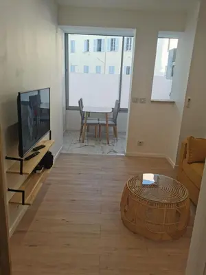 a living room with a television and a table at Halévy Résidence in Nice
