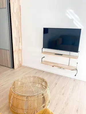 a wicker ottoman in a living room with a television at Halévy Résidence in Nice