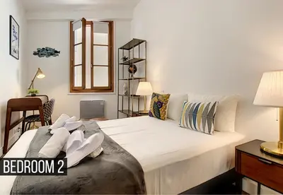 a bedroom with a large white bed with a window at Coeur Vieux Nice - Place Rossetti in Nice