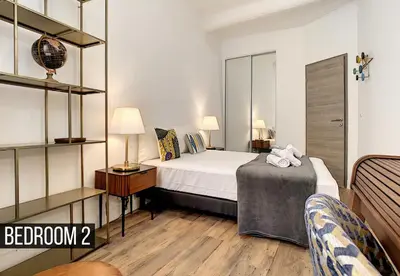 a bedroom with a bed and two lamps and a couch at Coeur Vieux Nice - Place Rossetti in Nice