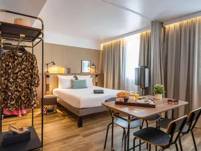 a hotel room with a large bed and a desk at Novotel Suites Nice Airport in Nice