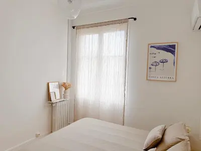 a white bedroom with a bed and a window at Ker Riviera in Nice
