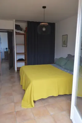 a bedroom with a bed with a yellow bedspread at Villa les Gabians in Saint-Laurent-du-Var