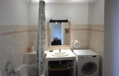 a bathroom with a sink and a washing machine at Villa les Gabians in Saint-Laurent-du-Var