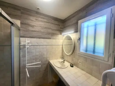 a bathroom with a sink and a mirror and a shower at Villa les Gabians in Saint-Laurent-du-Var