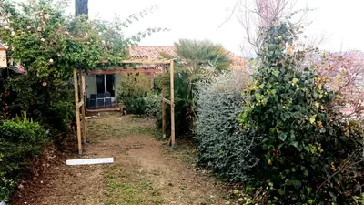 a garden with a gate and a hedge at Villa les Gabians in Saint-Laurent-du-Var