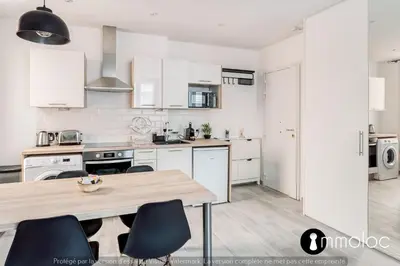 a kitchen with white cabinets and a wooden table at Hyper central studio 2 minutes walk from 