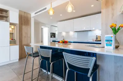 a kitchen with blue and white cabinets and stools at VUE DES ANGES AP4238 By Riviera Holiday Homes in Nice