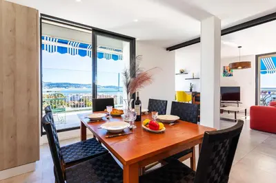 a dining room with a wooden table and chairs at VUE DES ANGES AP4238 By Riviera Holiday Homes in Nice