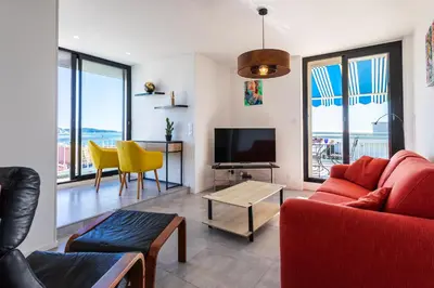 a living room with a red couch and a television at VUE DES ANGES AP4238 By Riviera Holiday Homes in Nice