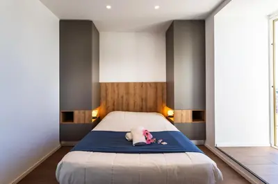 a bed with a stuffed animal laying on a blue blanket at VUE DES ANGES AP4238 By Riviera Holiday Homes in Nice