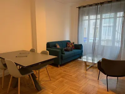 a living room with a blue couch and a table at Promenade des Anglais à côté du Negresco in Nice