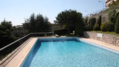 a swimming pool in a yard next to a building at 3 pièces vue mer et piscine quartier Parc Impérial in Nice